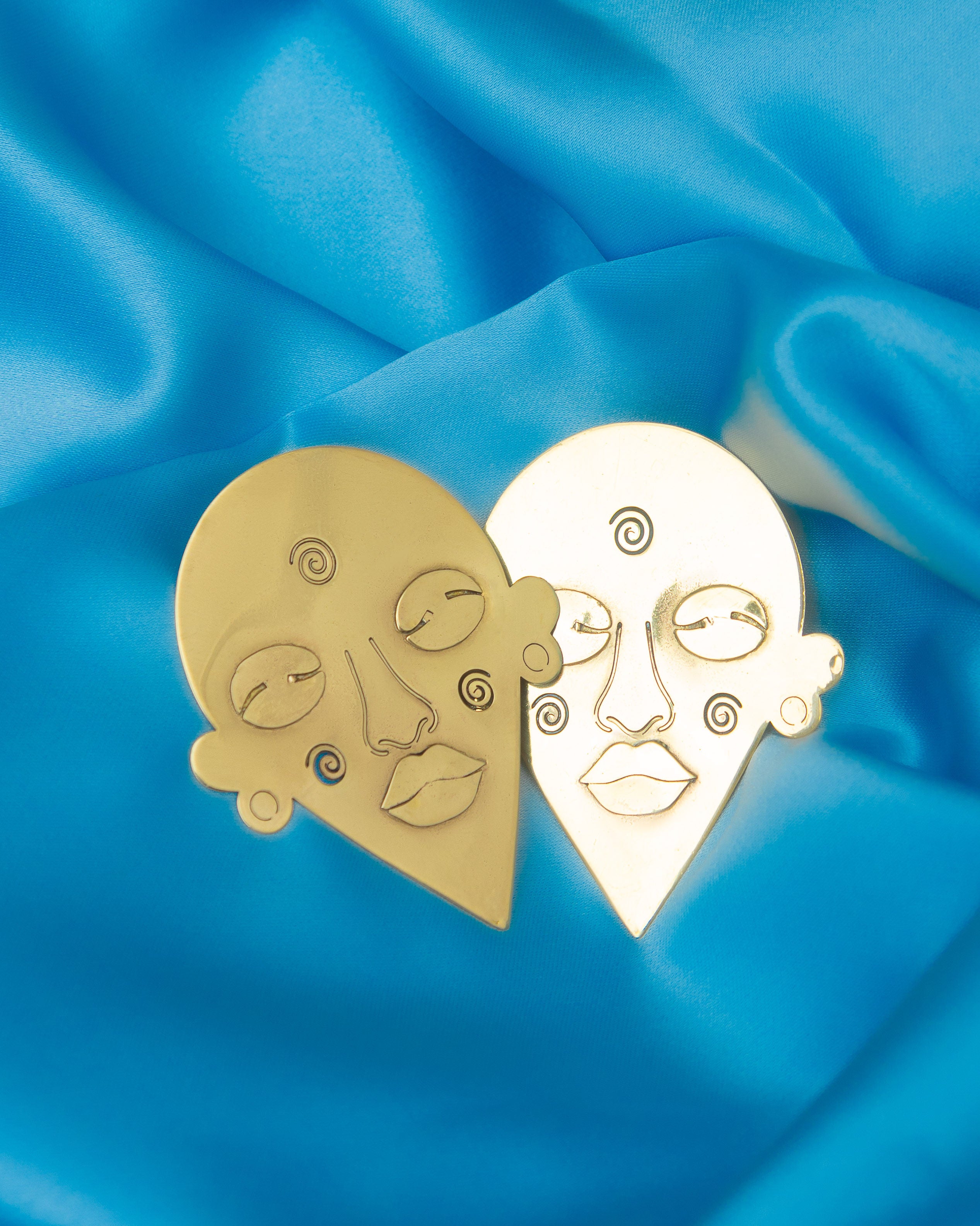 Handmade brass mask earrings symbolising strength by Adjeley Jewellery